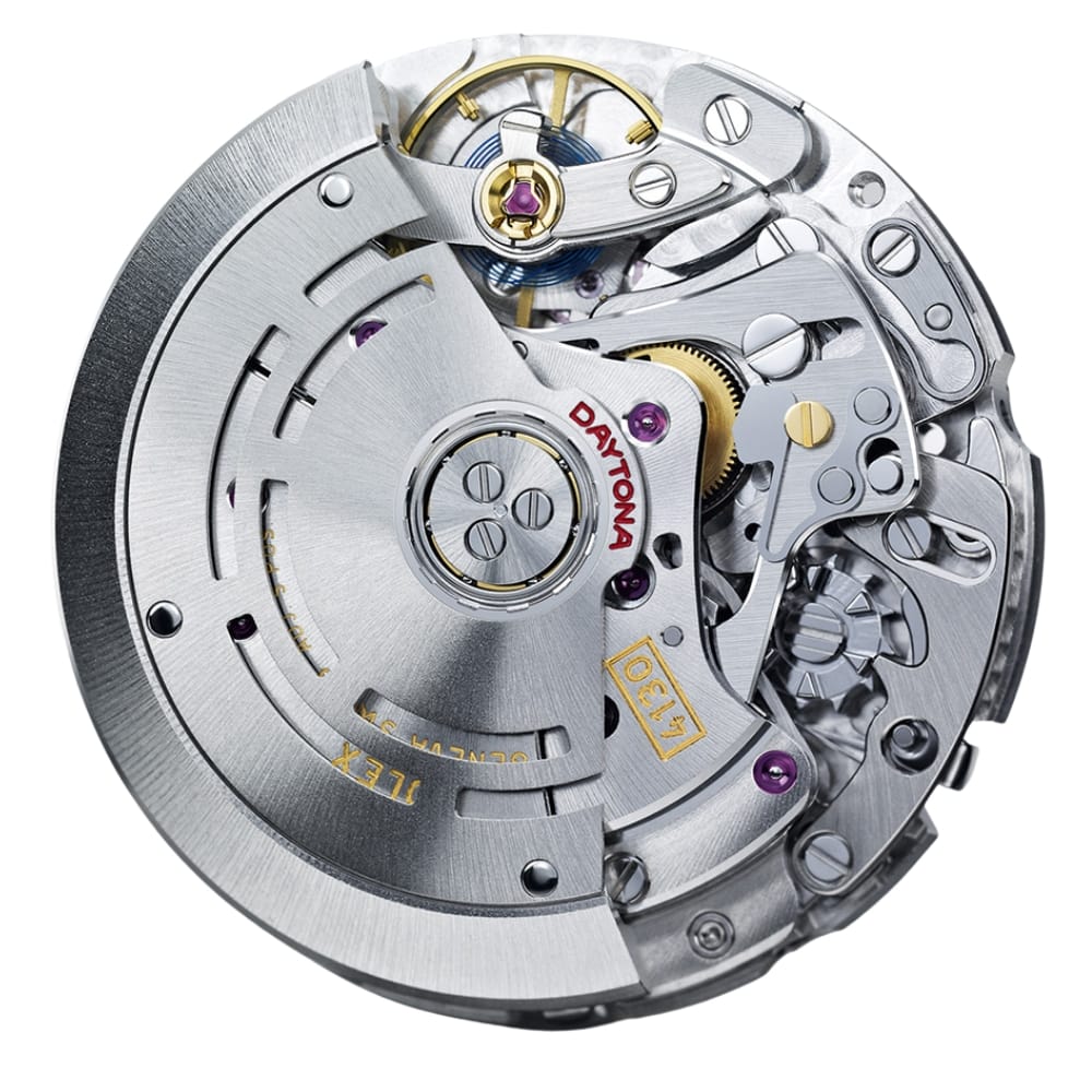 Close-up of a mechanical watch movement with visible gears, screws, and “Daytona” engraved on a metal part.