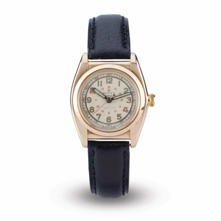 A gold Rolex Oyster 3009 wristwatch with a black leather strap and a white dial displaying both 12 and 24 hour markers.