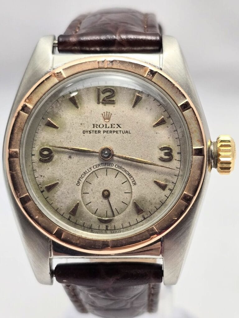 A vintage Rolex Oyster Perpetual 5052 watch with a brown leather strap and a gold-toned bezel.