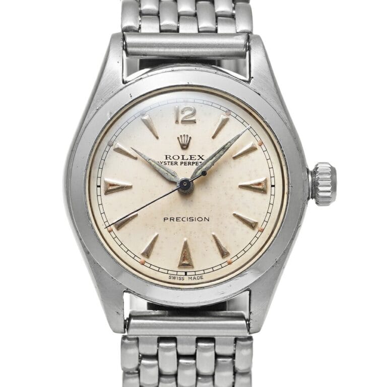 A vintage Rolex Oyster Perpetual 5006 Precision watch featuring a silver band and elegant cream dial.