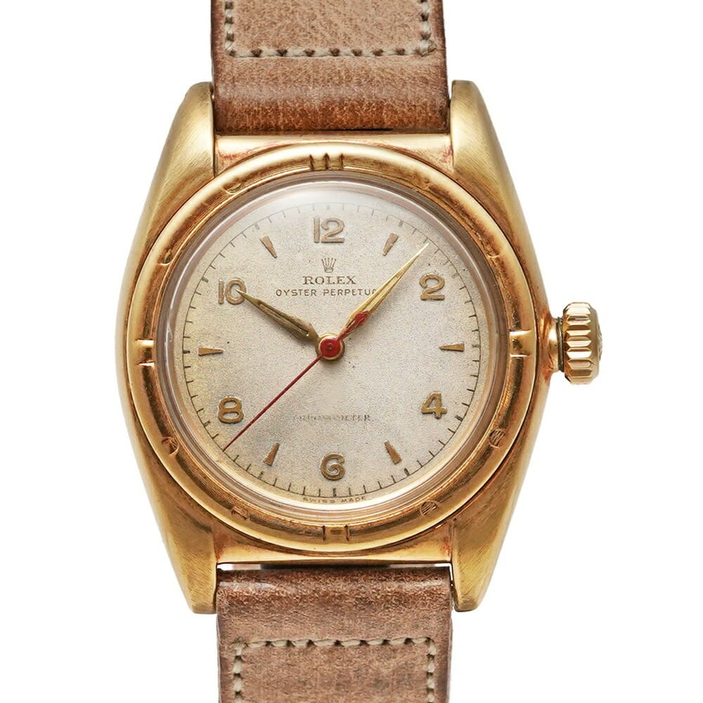 A vintage gold Rolex Oyster Perpetual 3458 watch with a tan leather strap and a simple dial.