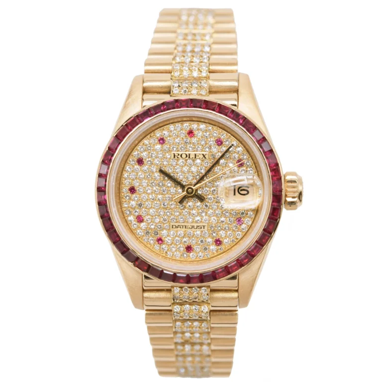 Gold Rolex Datejust 69098 watch with diamond-studded face and band, ruby bezel, and date display at 3 o’clock.