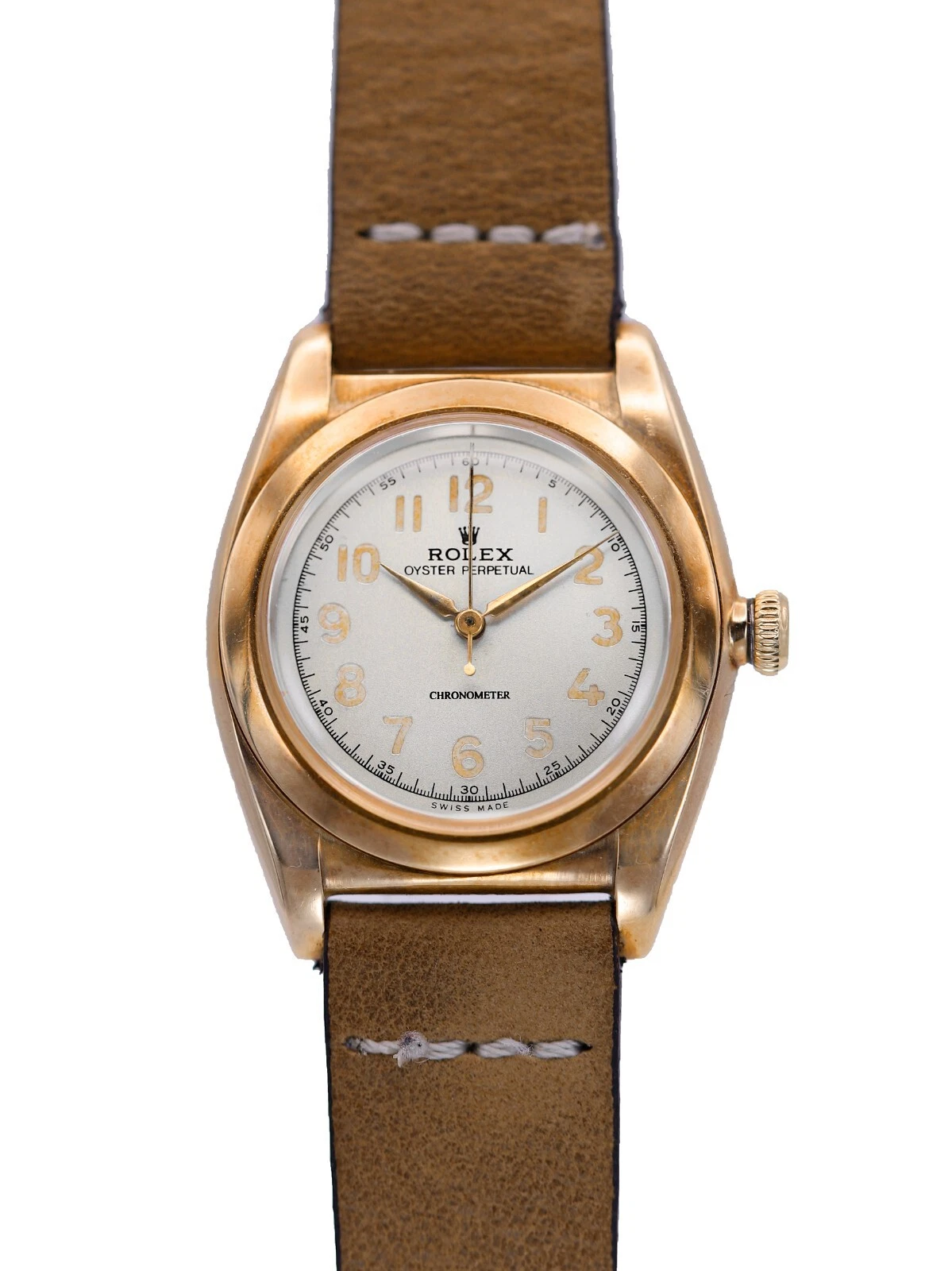 A vintage Rolex Oyster Perpetual watch featuring the classic 3131 movement, with a brown leather strap and an elegant gold case.