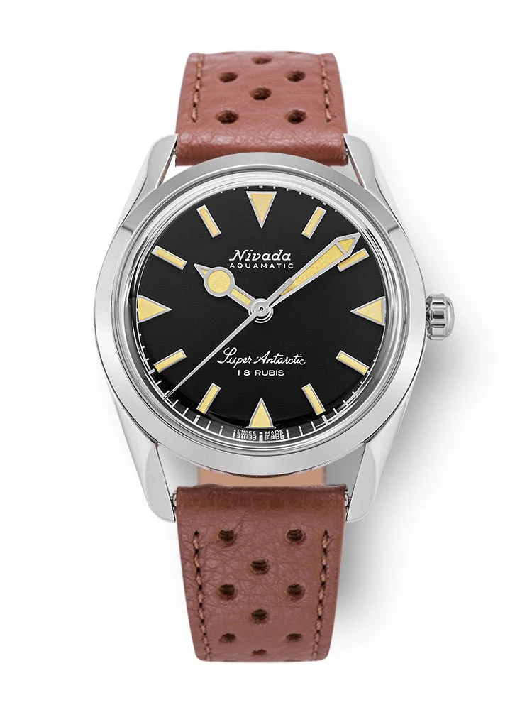 Discover the Nivada Grenchen Super Antarctic, featuring a black dial, silver case, tan perforated leather strap, and distinct yellow triangle hour markers. Model 35013M41 combines classic style with modern craftsmanship.