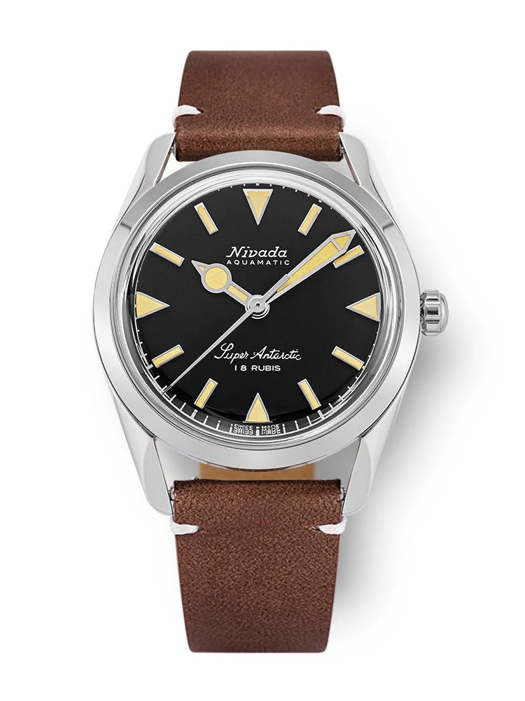 A silver Nivada Grenchen Super Antarctic watch with a black dial, beige markers, and a brown leather strap.