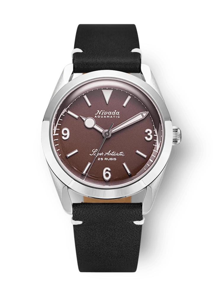A Nivada Grenchen Super Antarctic wristwatch with a brown dial, silver case, and black leather strap, displaying 9, 12, and 3 numerals. Model: 32040A15.