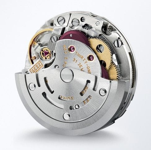 A close-up of a mechanical watch movement with visible gears and intricate metal components.