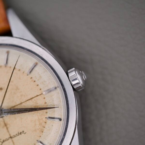 Close-up of the Omega Automatic Seamaster 2802 Cross Hair Waffle Dial watch crown and its aged, cream-colored waffle texture.