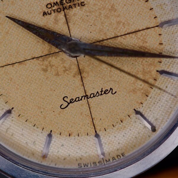 Close-up of an Omega Automatic Seamaster 2802 featuring a rare Cross Hair waffle dial, showcasing its aged and textured design with visible hands.