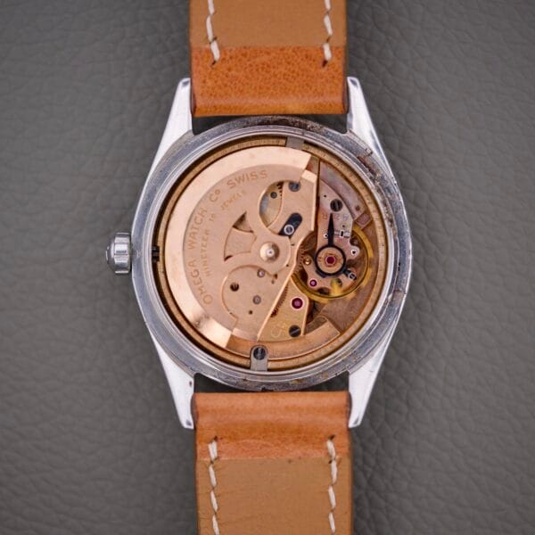 Back view of an Omega Automatic Seamaster 2802 Cross Hair Waffle Dial wristwatch with a tan leather strap, displaying its exposed automatic mechanical movement.