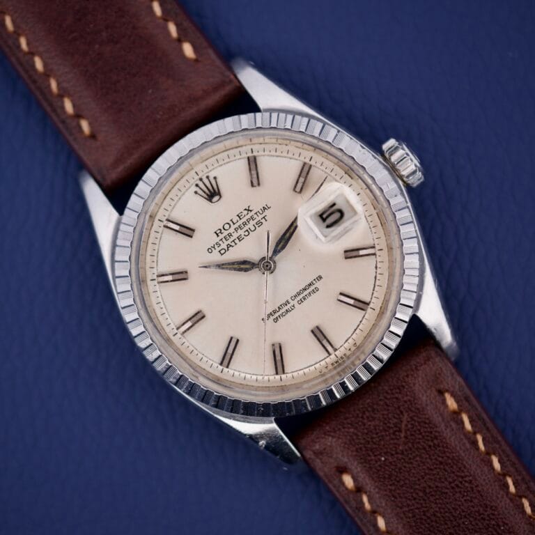 Rolex Datejust 1603 Silver Dial Alpha hands, featuring a brown leather strap, showcased against a blue background.