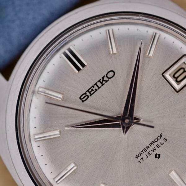 Close-up of the Seiko 6602-8040 Manual Wind Date Sunburst Dial, showcasing its striking sunburst dial, date display, and waterproof text with 17 jewels.