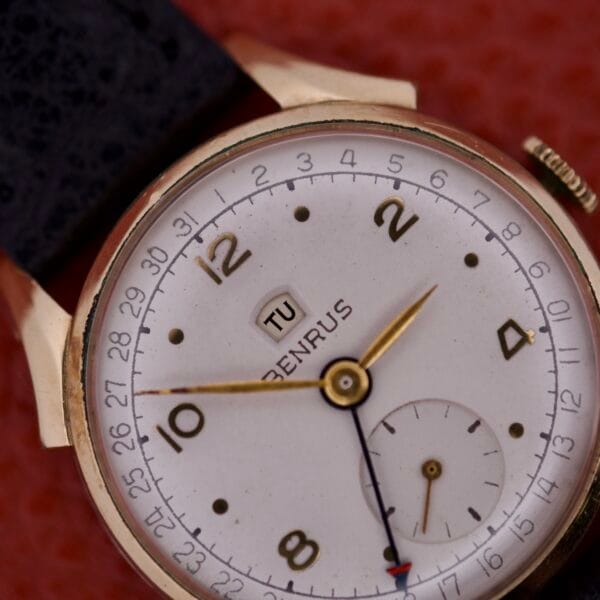 Close-up of a Benrus Triple Calendar Pointer Model CE 13 wristwatch showing the time 8:24, with the date display set to Tuesday.