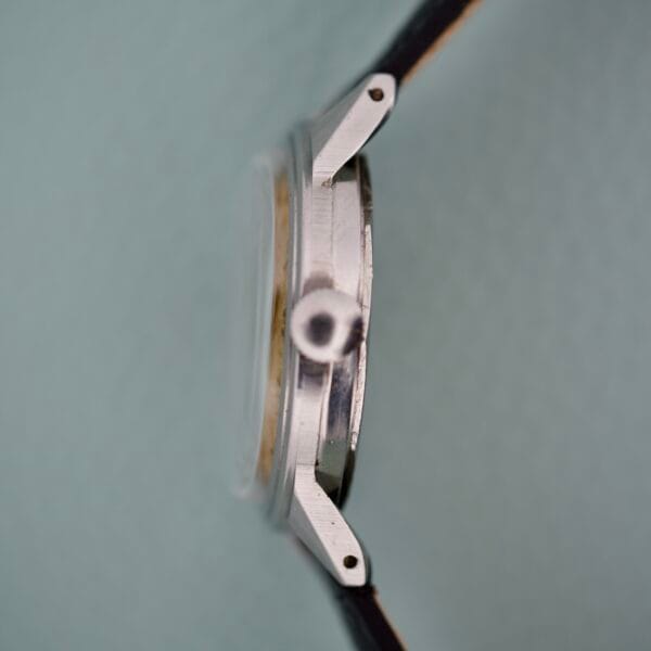 Side view of the Movado Caltrava Ref. 18271 Tropic Dial Stainless Steel with black strap, shown on a light background.