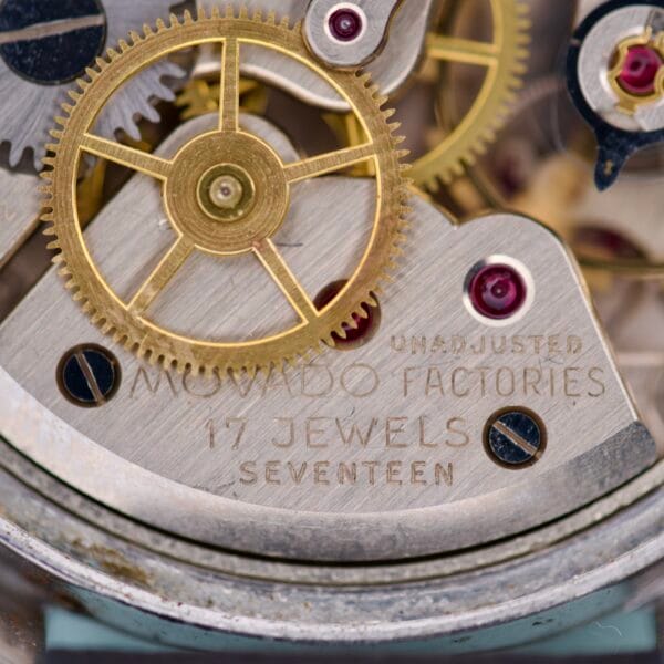 Close-up of watch gears with MOVADO FACTORIES 17 JEWELS UNADJUSTED engraved on stainless steel, highlighting the refined craftsmanship of the Movado Caltrava Ref. 18271 Tropic Dial Stainless Steel.