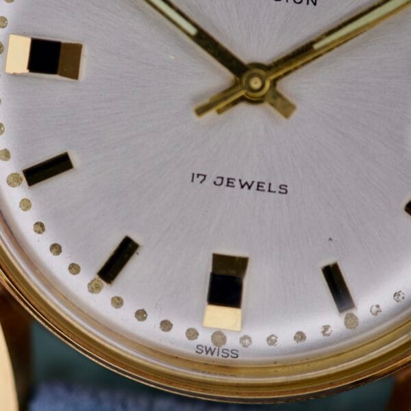 Close-up of the Gruen Precision Date 510RSS CA Sunburst Dial watch face with gold hands, black and gold hour markers, 17 JEWELS text, and an eye-catching sunburst dial.