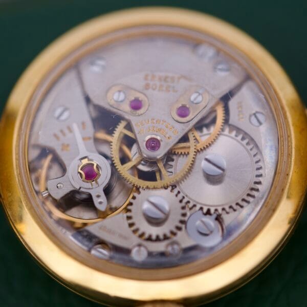 Close-up of an Ernest Borel Cocktail Kaleidoscope White Dial watch movement, showcasing visible gears and jewels beneath the engraved ERNEST BOREL SEVENTEEN 17 JEWELS, reflecting the brands iconic artistry.