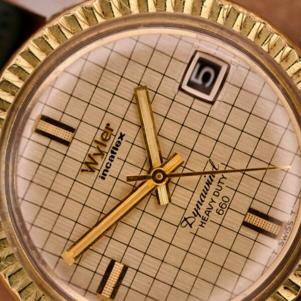 Close-up of a Wyler Dynawind Heavy Duty 660 Life Guard gold wristwatch, showing the time 4:30 and a date window with the number 5.