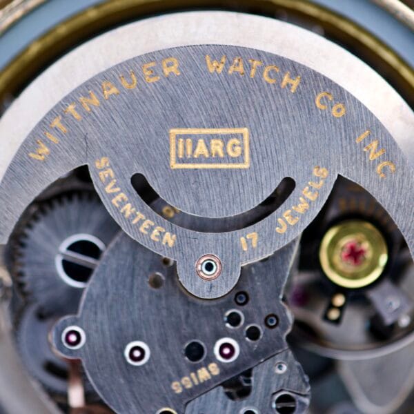 Close-up of the inner mechanism of the Wittnauer Automatic Black Gilt Dial Cal. 11ARG watch, highlighting its gears and engraved text.