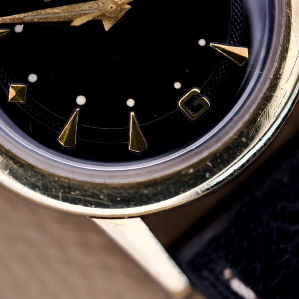 Close-up of the Eterna Matic Black Dial 14k Gold Capped Case wristwatch, featuring geometric hour markers and a sleek black leather strap.