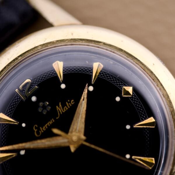 Close-up of an Eterna Matic Black Dial 14k Gold Capped Case watch, highlighting its elegant black dial with 14k gold hands and markers.