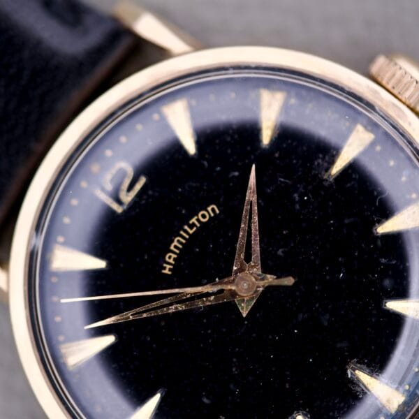 Close-up of the Hamilton Caliber 671 Manual Wind Black Gilt Dial wristwatch, featuring gold markers and hands on a black gilt dial.