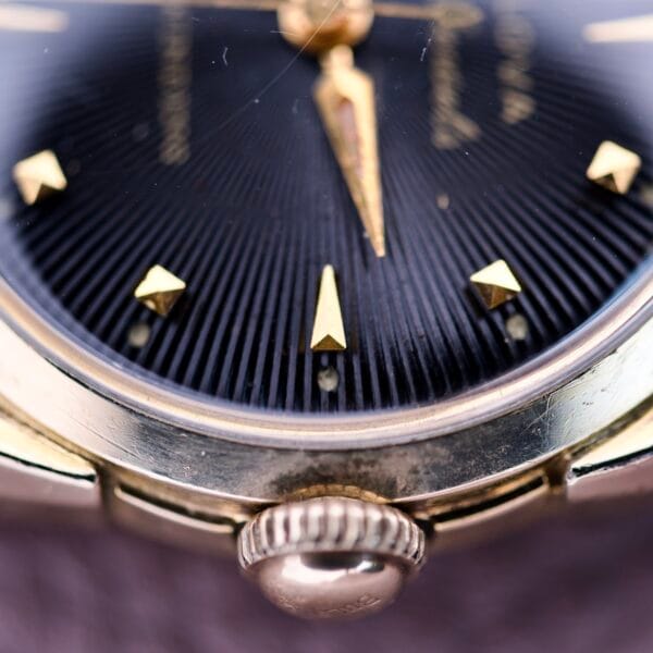 Close-up of the 1957 Bulova 23 Jewels Self Winding Cal. 10BPAC, featuring gold hour markers, a textured black dial, and “23 Jewels Self Winding” elegantly inscribed.