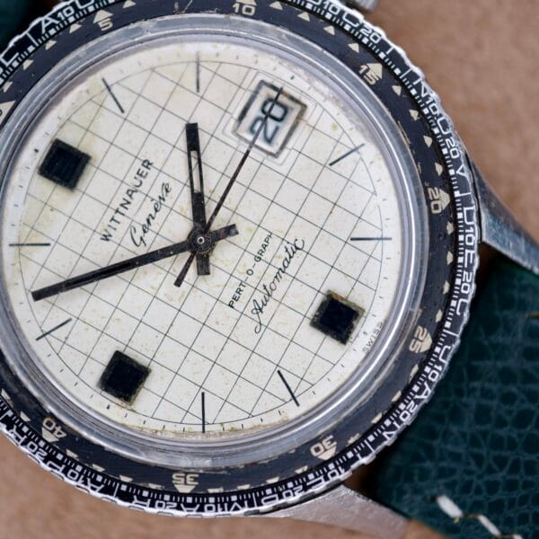 Close-up of a Wittnauer Pert-O-Graph Ref. 7005 with its Rare Pert-O-Graph Scale Bezel, grid-patterned dial, and green leather strap.