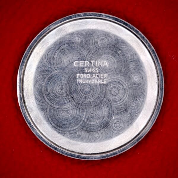 Rose gold tone Certina Ref. 7400-207 watch case back with concentric circles on red, engraved text, and Cal. 28-10 movement details.