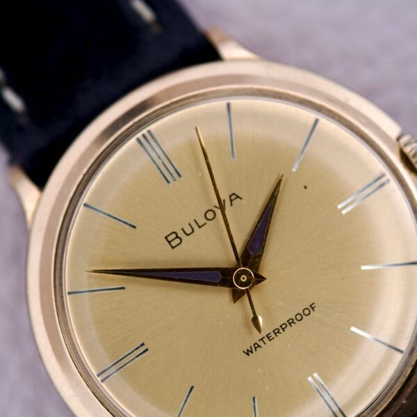 Close-up of the Bulova Gold Sunburst Dial & Case Cal. 11AFC, showcasing its gold sunburst dial, black hands, and WATERPROOF marking on the face.