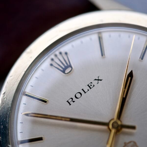Close-up of a Rolex Presentation Watch Ref. 7002, featuring a silver face, gold hands, 14k gold filled hour markers, and the Cal. 1520 movement.