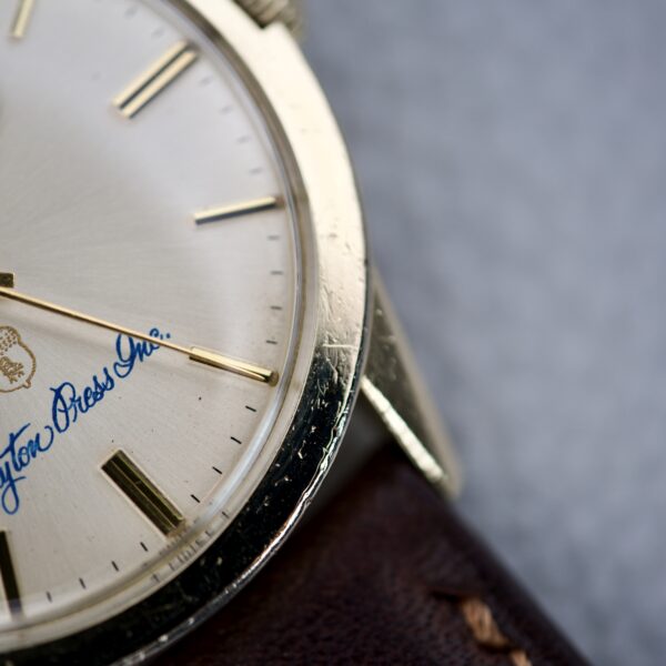 Close-up of a Rolex Presentation Watch Ref. 7002 14k Gold Filled Cal. 1520 featuring a cream dial, gold hour markers, and a brown leather strap.
