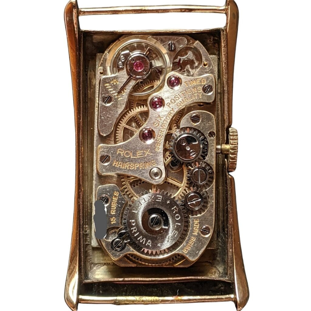 Close-up of an exposed Rolex watch movement, showing detailed gears, cogs, and mechanical parts.