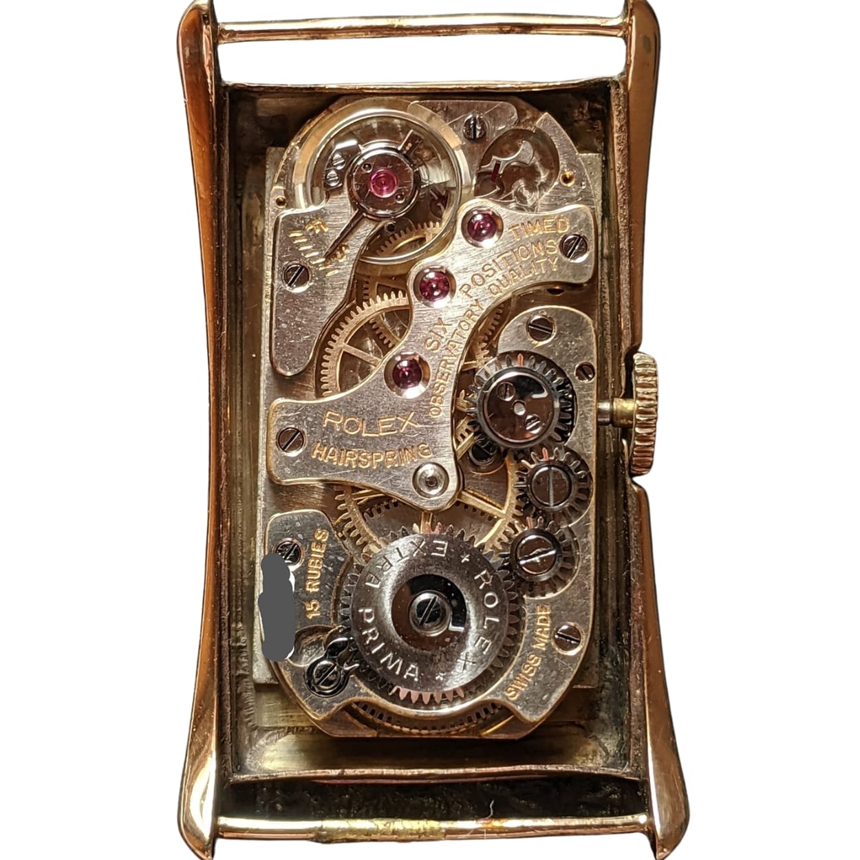 Close-up of an exposed Rolex watch movement, showing detailed gears, cogs, and mechanical parts.