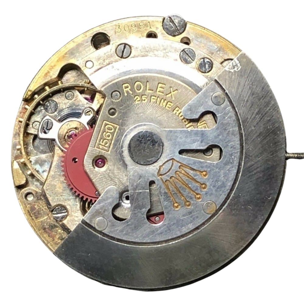 Close-up of a Rolex 1560 watch movement with visible gears, engravings, and the Rolex crown logo.