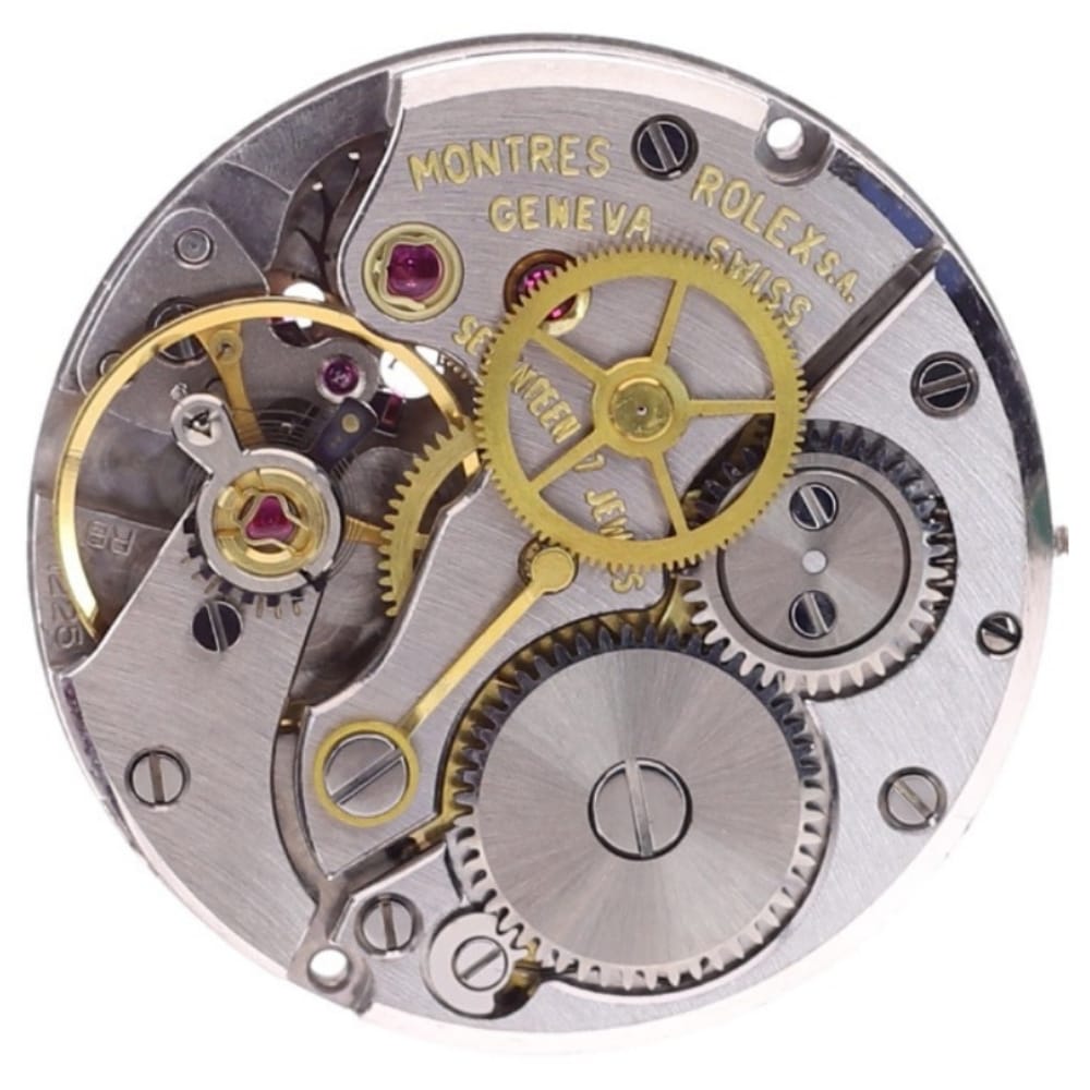 Close-up of intricate Rolex watch movement with visible gears, cogs, and engraved text on metal parts.