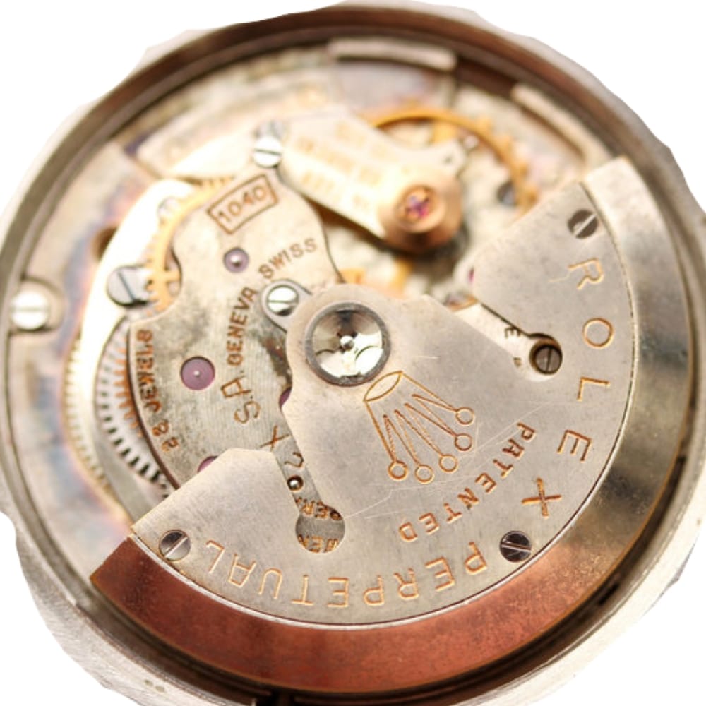 Close-up of a Rolex watch movement mechanism showing gears and engraved Rolex Perpetual text.