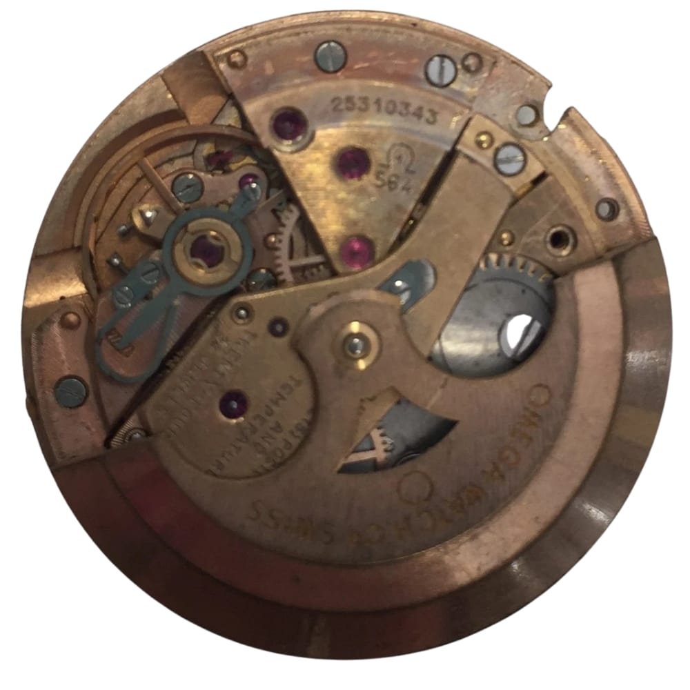 Close-up of a vintage Omega watch movement showing gears, screws, and engraved markings.