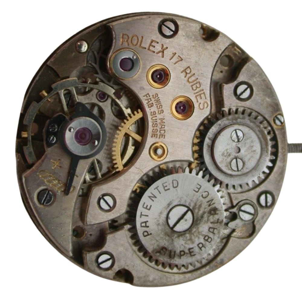 Close-up of a vintage Rolex 10 1/2 watch movement showing gears, screws, and engraved text.