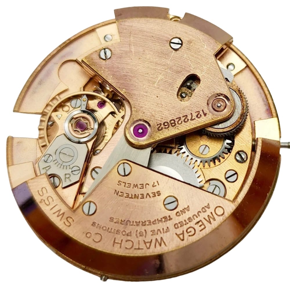 Close-up of an Omega watch movement showing gears, jewels, and engraved markings.