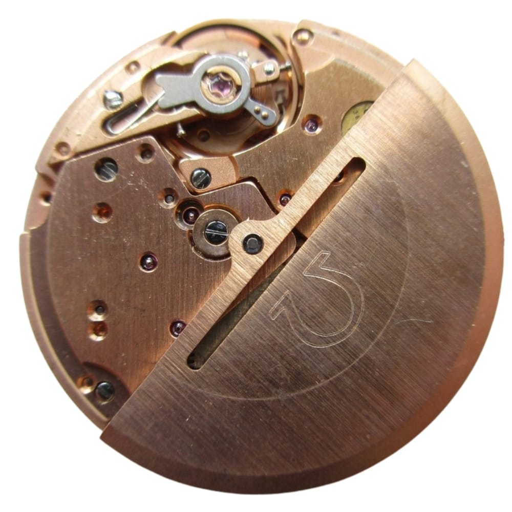Close-up of a copper-colored mechanical watch movement with visible gears and intricate parts.