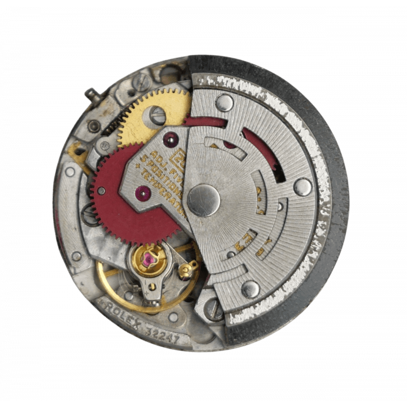 Close-up of a mechanical watch movement with gears, screws, and metal components visible.