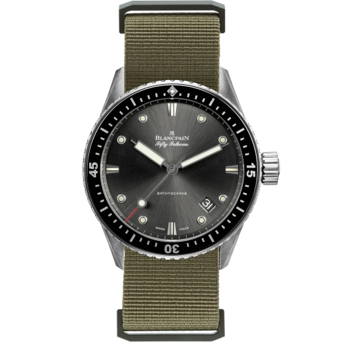 A stainless steel Blancpain Fifty Fathoms watch, model 5000-1110-NAKA, features a black dial and olive green fabric strap, showing the time 10:10.