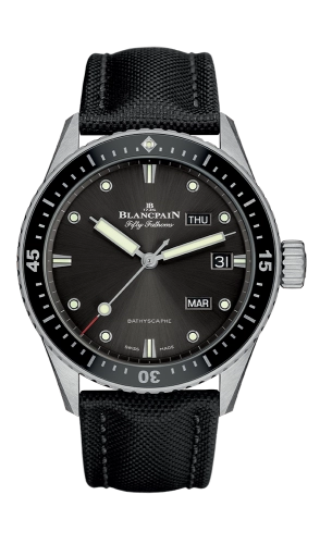 A black Blancpain Fifty Fathoms luxury dive watch with luminous markers, day and date windows, and a fabric strap.