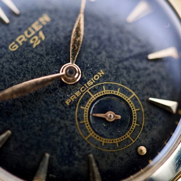 Close-up of a vintage Gruen Barclay "Spider" Ref. 335-723 watch face, featuring 21 Jewels Cal. 335 movement with gold hands and markers.