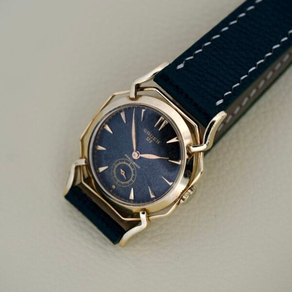 Gruen Barclay "Spider" Ref. 335-723 wristwatch featuring a blue face, 21 Jewels Cal. 335, and a blue leather strap displayed on a light surface.