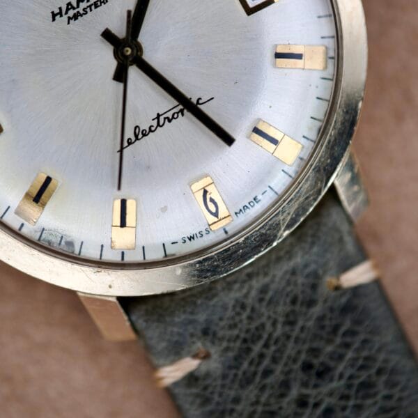 Close-up of the Hamilton Masterpiece Electronic Date Ref. 981569 wristwatch with Cal. 702 movement and leather strap, displaying the time at 12:14.