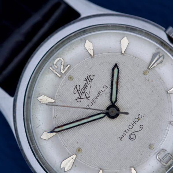 Close-up of a Piguette Antioch 17 Jewels Manual Wind wristwatch with silver markers and black hands in a stainless steel case, "17 Jewels" on the dial, displaying 7:22:29.