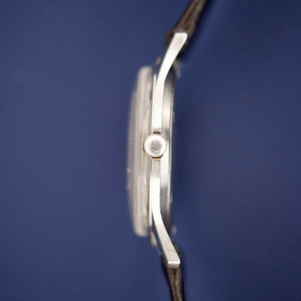 Side view of the Piguette Antioch 17 Jewels Manual Wind wristwatch with a black strap and stainless steel case, set against a plain dark blue background.