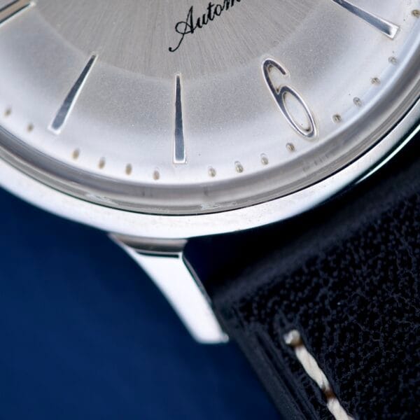 Close-up of a Hamilton Accumatic X Sunburst Dial Stainless Steel Cal. 667 wristwatch face, highlighting the number 6 and part of its black leather strap.